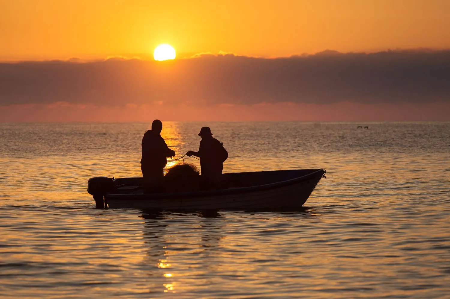 Pêcheurs locaux travaillant avec leurs filets de pêche au lever du soleil